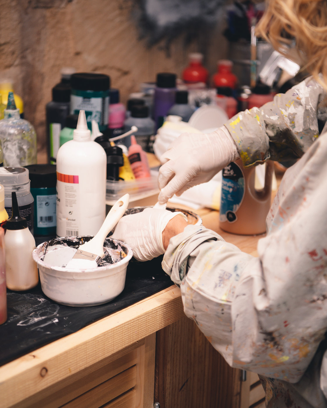 Karin Galler mischt Farben an ihrem Arbeitstisch im Atelier